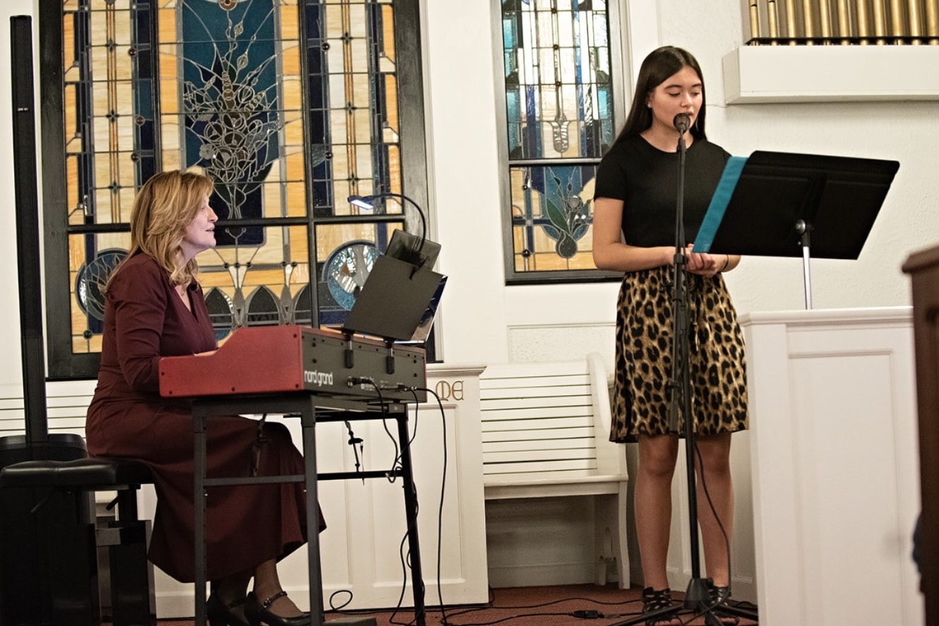 Piano teacher and student in a warm music studio lesson